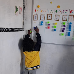 A child working at the numbers wall in class